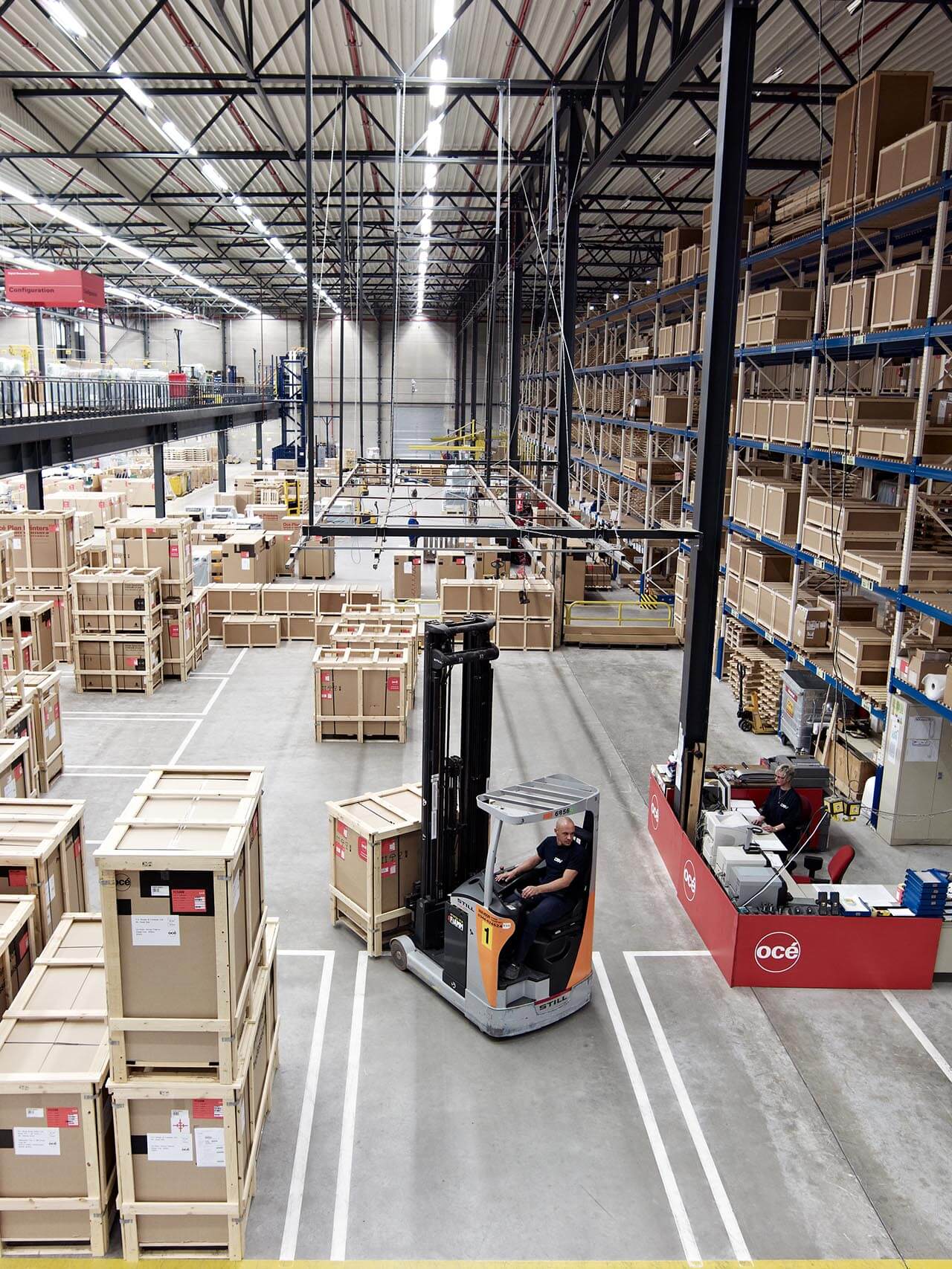 An expansive warehouse featuring rows of tall shelving units filled with neatly stacked crates and boxes